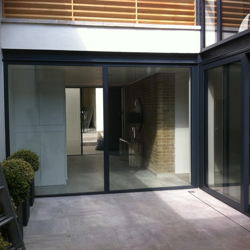Floor-to-ceiling sliding doors opening to courtyard in Northolt